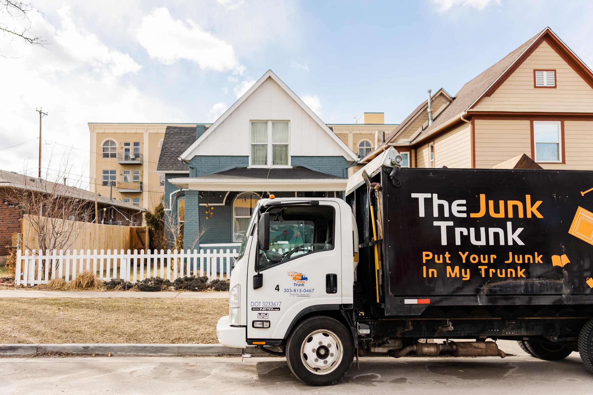 The Junk Trunk truck staged beside a house at a residential site