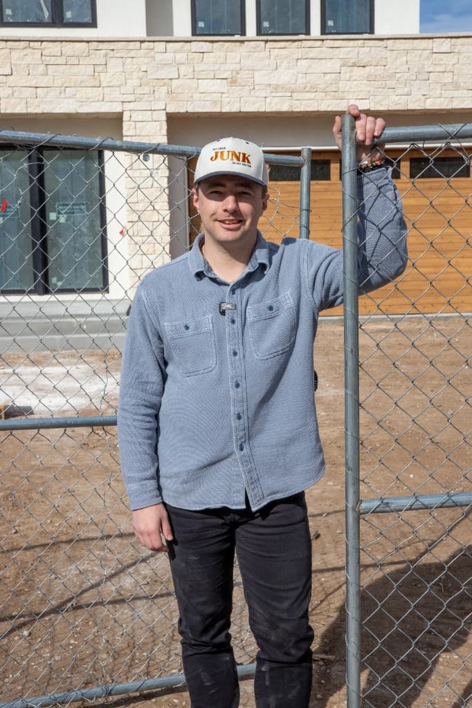 Nathan from The Junk Trunk standing at a temporary fence installation