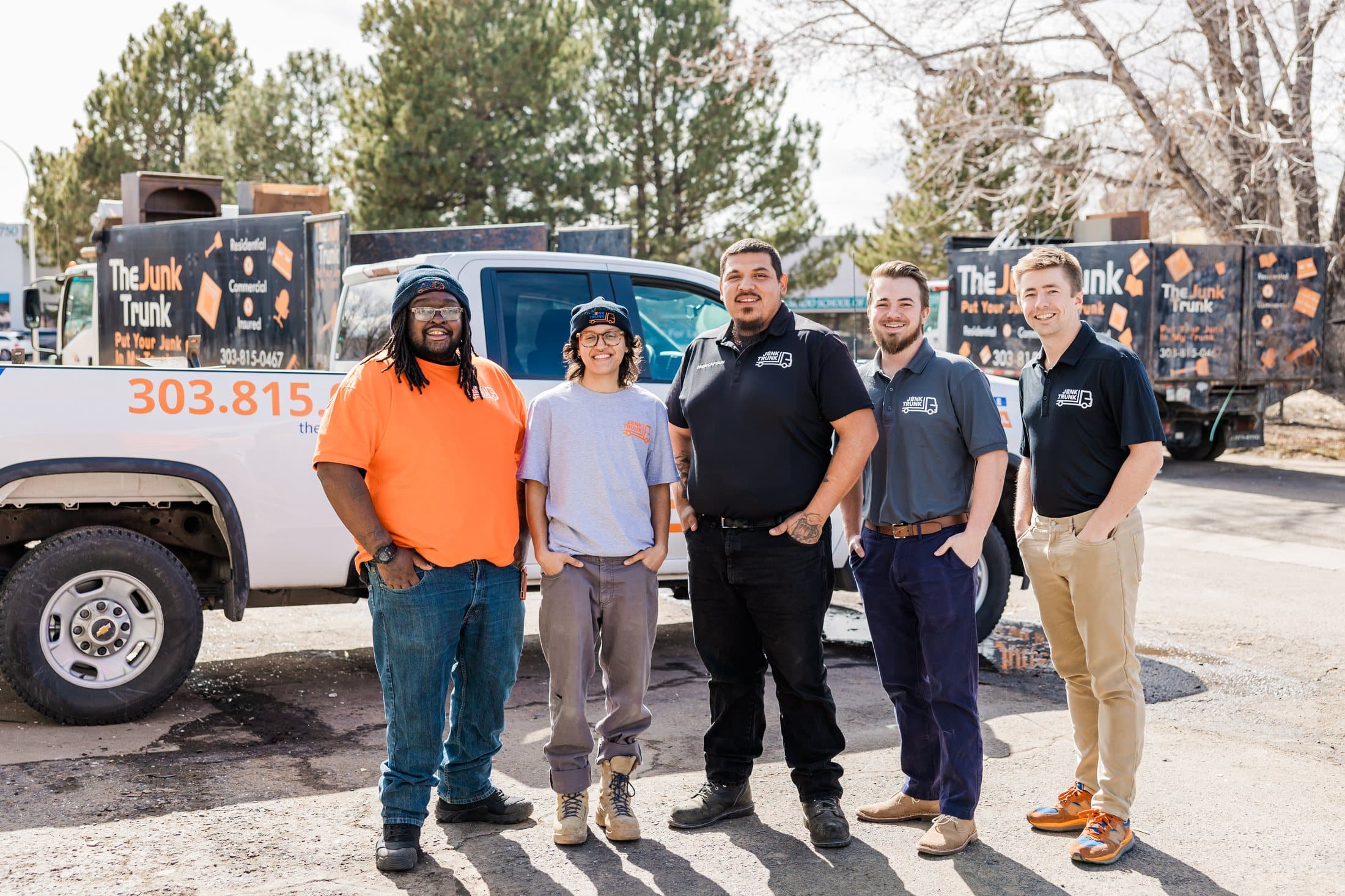 The Junk Trunk crew standing in front of a branded pickup