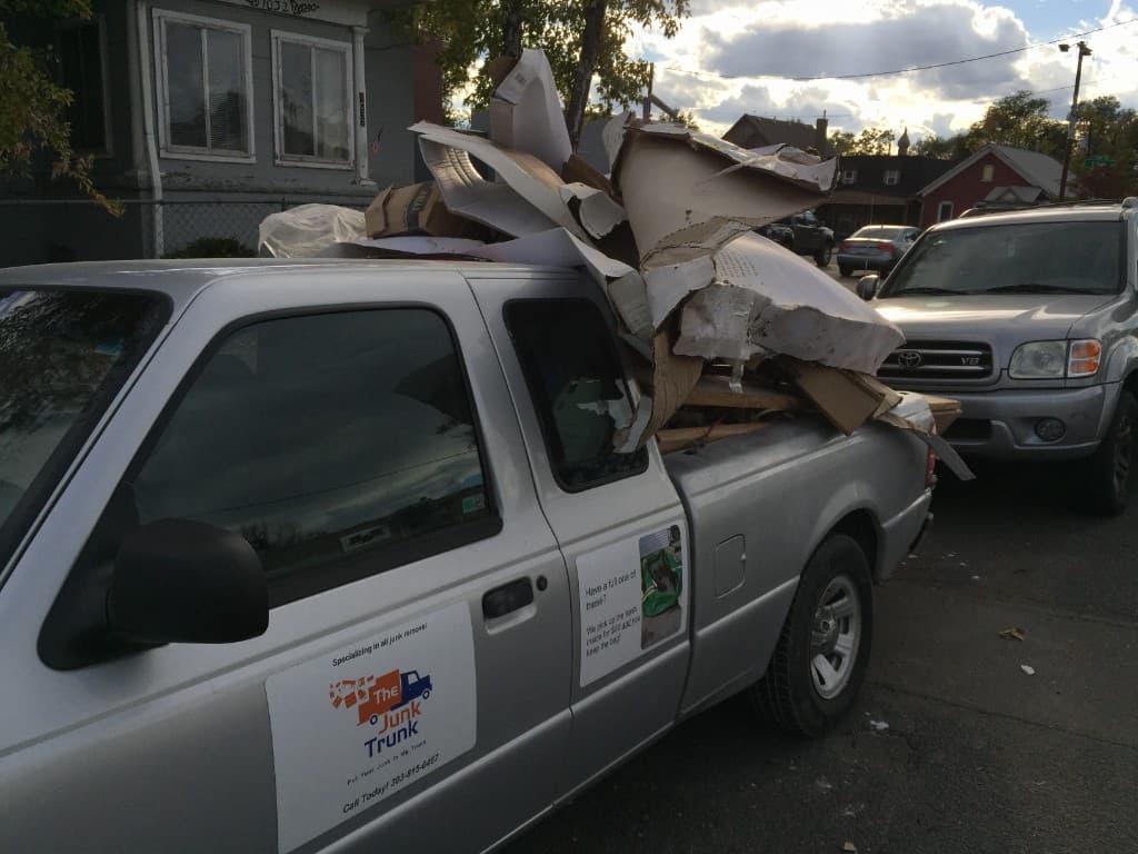 Old Junk Trunk branded truck overflowing with cardboard on a Denver street