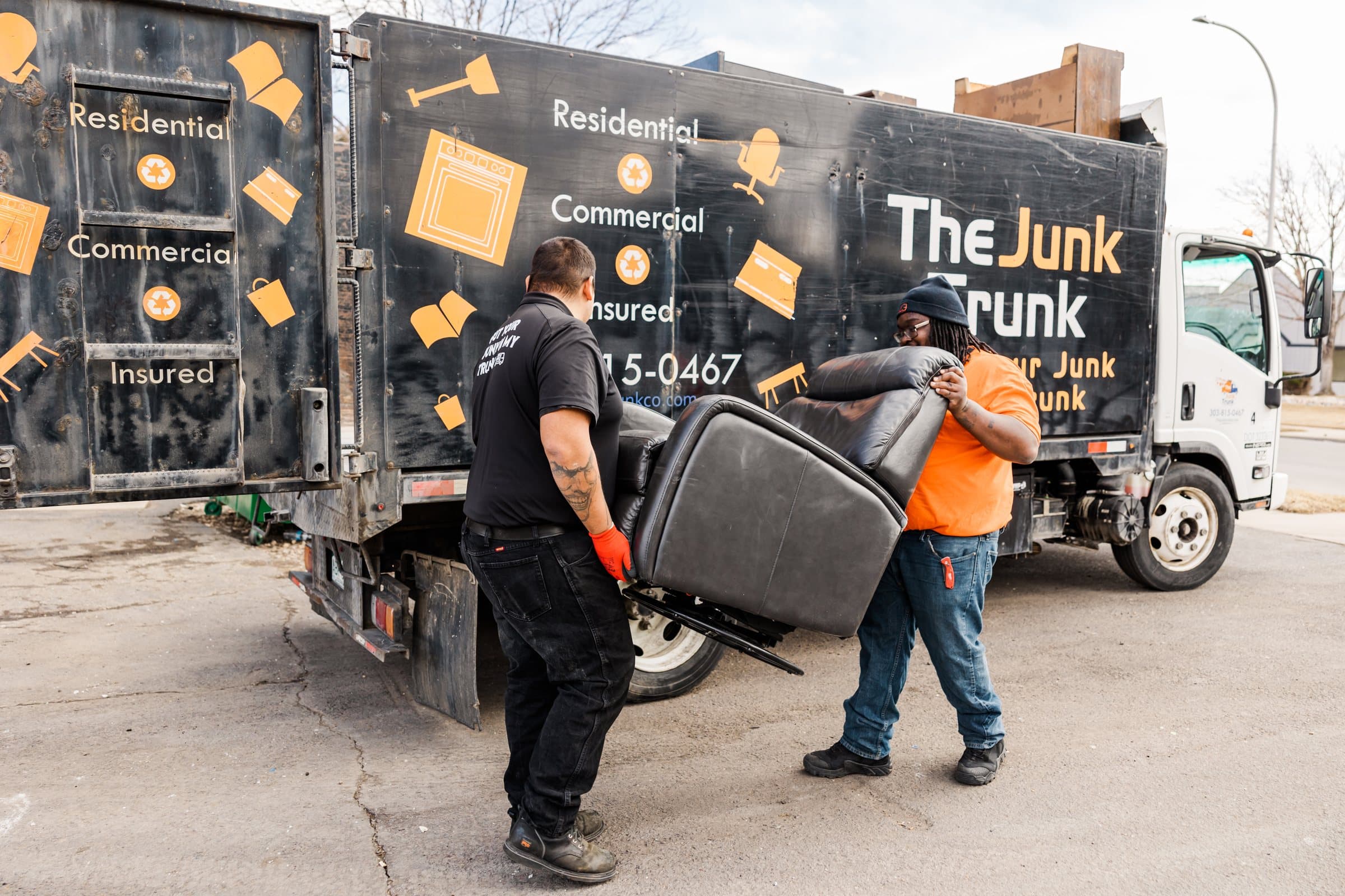 Junk Trunk crew loading a bulky chair into the truck